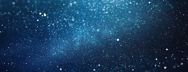 Sparkling blue bokeh background resembling snowfall.