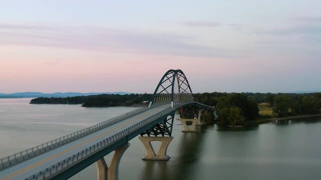 Drone shot around the Lake Champlain Bridge, vibrant dusk sky in Vermont, USA
