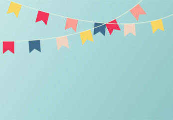 Hanging festive colorful garland of paper flags on blue wall background. Holiday decorations concept.