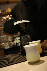 A barista is making hand-brewed coffee in a coffee shop