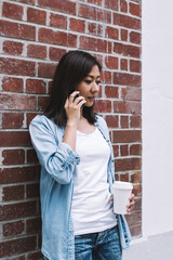 Asian woman speaking on smartphone on street