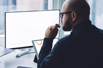 Concentrated businessman using gadgets in office