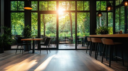 A sleek dining area featuring dark chairs and tables set against large windows, with a view of a vibrant outdoor garden under a warm, inviting sunset light.