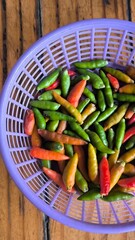 Chili peppers in a purple basket on a wooden table