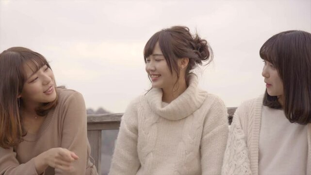 海沿いのデッキでおしゃべりをする女性たち