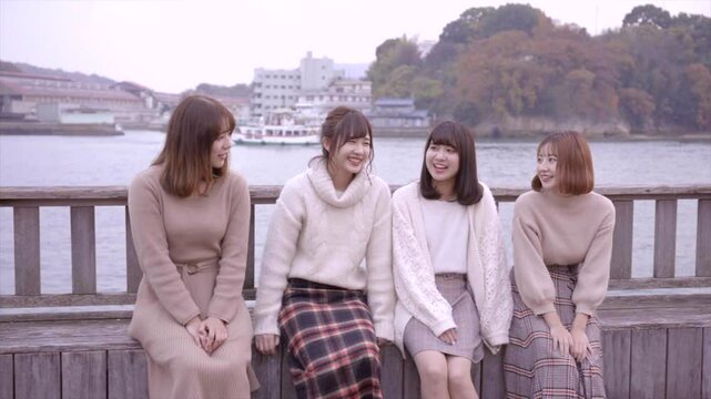 海沿いのデッキでおしゃべりをする女性たち