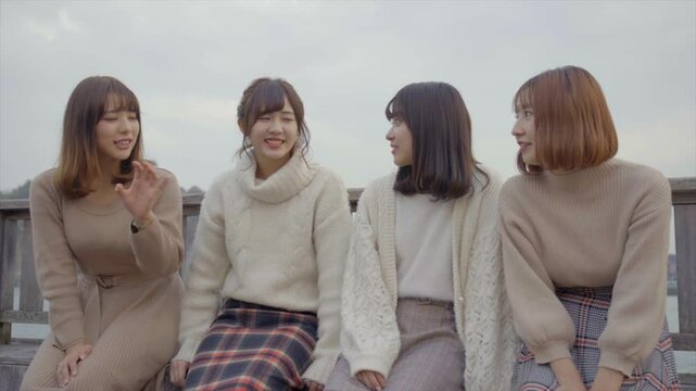 海沿いのデッキでおしゃべりをする女性たち