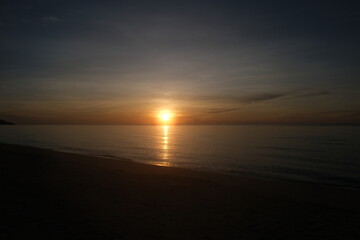 The sun rises at the sea in the morning.