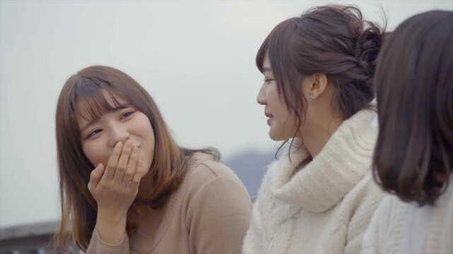 海沿いのデッキでおしゃべりをする女性たち