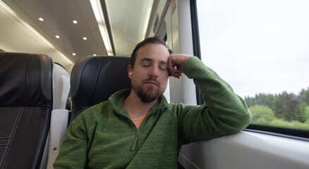 Tired man sleeping on train, long work day, commuter, resting.