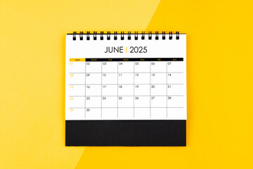 Top view on June desk calendar for 2025 year on yellow background for schedule to make appointment.