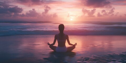Woman in yoga pose meditating on sun set on the beach