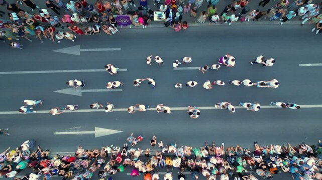 Aerial top down shot of crowds of people dancing in the streets. High angle drone footage of people street dancing salsa, bachata, west coast swing and tango seen from above. Open air music festival.
