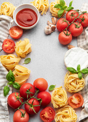 Italian food background featuring tomatoes, pasta, garlic, cheese, basil and tomato sauce creating a frame