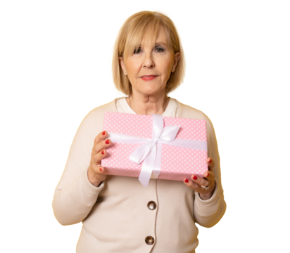 Portrait of cheerful positive glad charming aged woman holding gift box in pink package standing isolated over transparent background. PNG transparent.