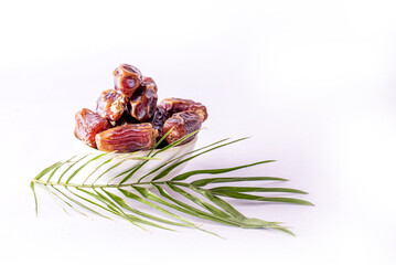 Dried date and green mint in a bowl on white table close up