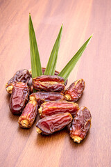 Dates or kurma on a wooden table, the favorite food of the holy ramadhan month.