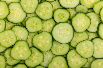 Fresh cucumbers sliced ​​into layers as a background. Cucumber background.