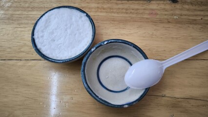 coconut milk custard in small porcelain cup (Thai dessert) in wooden dish on table.