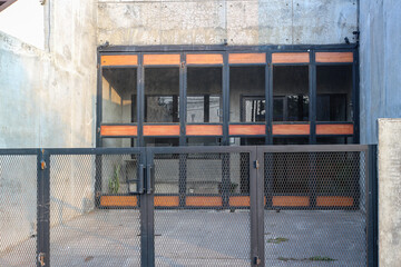 A close-up view of a modern building with a metal gate and a concrete wall. Modern Architecture...
