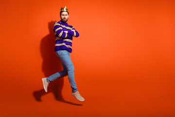 Fototapeta premium Full size photo of nice young male crossed hands jump run wear trendy striped violet outfit isolated on orange color background