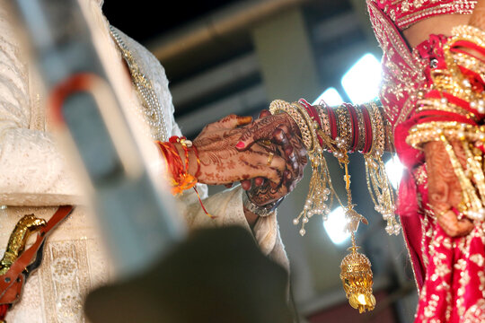 Traditional indian wedding ceremony, groom holding hand in bride hand. Timeless moment of togetherness, symbolizing love and commitment.	