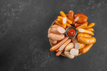 Set of different types of sausages, Boiled meat sausages with ketchup on a dark background. top...