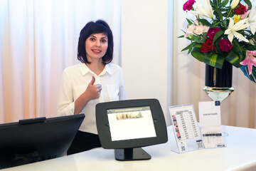 Woman at the hotel counter greeting and guiding guests to their hotel rooms.