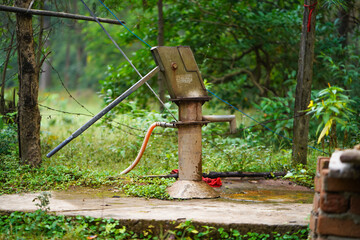 Old Hand Pump in Forest Setting, Hand Pump in Natural Greenery, Village Water Source in Jungle Stock Photo.



