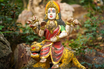 Durga maa forest indian goddess, sacred idol in jungle, nature-surrounded deity statue, van devi idol in forest, ancient temple in woods, rural deity sculpture, forest shrine stock photo.

