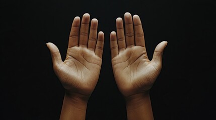 Two open hands against a dark background, symbolizing openness and communication.