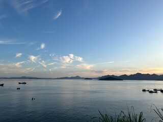 Sunset Over the Sea with Distant Hills and Soft Glowing Sky
