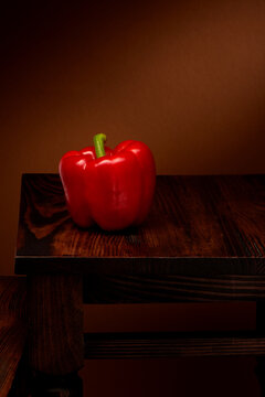 Fresh organic red bell pepper on dark wooden table