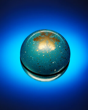 Chocolate candy with golden snowflake on bright blue background