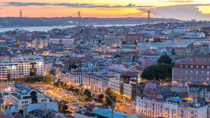 Naklejka premium Lisbon after sunset aerial panorama view of city centre with red roofs at Autumn day to night timelapse, Portugal