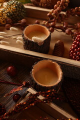 Cozy autumn decor with candles, pinecones, and berries, creating a rustic, seasonal ambiance perfect for fall.