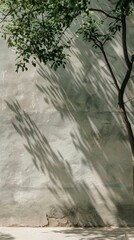 Shadows of tree branches create a natural pattern on a concrete wall, blending nature with urban textures.