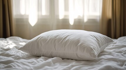 Comfortable white pillow lying on bed in sunny bedroom