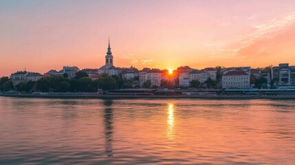 Obraz premium Cityscape at sunset with a river in the foreground.