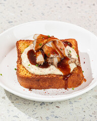 Portion of brioche breakfast toast with turkey brisket and sauce