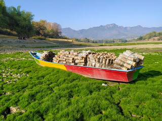 A wooden boat in reservoir that drought,the water evaporates due to the long dry season.