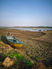 A wooden boat in reservoir that drought,the water evaporates due to the long dry season.