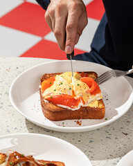 Man eating brioche breakfast toast with egg and salmon