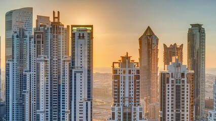 Modern residential and office complex with many towers aerial timelapse at sunset in Business Bay, Dubai, UAE.