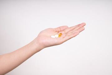 Woman hands taking multiple pills , vitamins D3 and Zinc, daily supplement vitamins isolated on white background