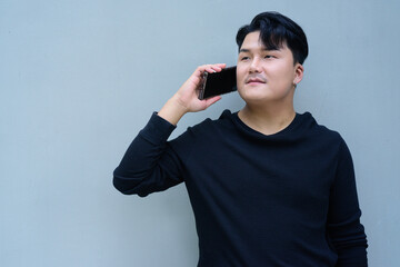 Portrait of Handsome Young Asian Man Against Plain Background Outdoors