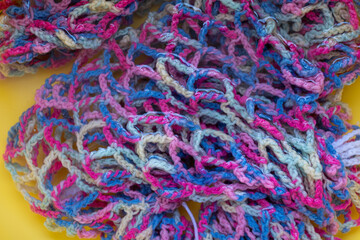 Bright knitted clothes in the water. Knitted texture in water. Abstract background.
