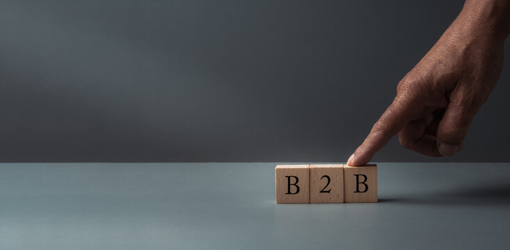 hand posing wooden blocks , concept of business to business ,on grey background