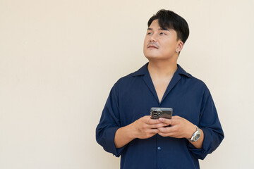 Portrait of Handsome Young Asian Man Against Plain Background