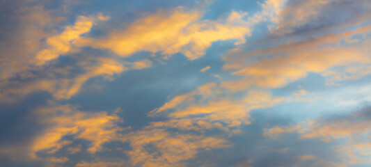 Orange sky and clouds background,Real majestic sunrise sundown sky background with gentle colorful clouds without birds. Panoramic, big size